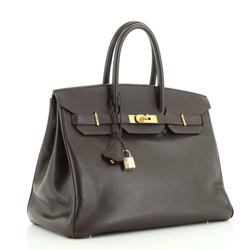 Condition: Damaged. Heavy splitting on top flap wax edge. Moderate wear on base corners, handles and closure strap, moderate creasing and scuffs on exterior. Cracking on handle wax edges, indentations and scuffs on interior base, scratches on