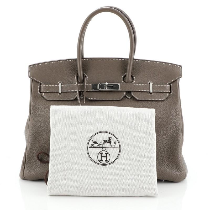 This Hermes Birkin Handbag Etoupe Clemence with Palladium Hardware 35, crafted in Etoupe neutral Clemence leather, features dual rolled handles, frontal flap, and palladium hardware. Its turn-lock closure opens to an Etoupe neutral leather interior
