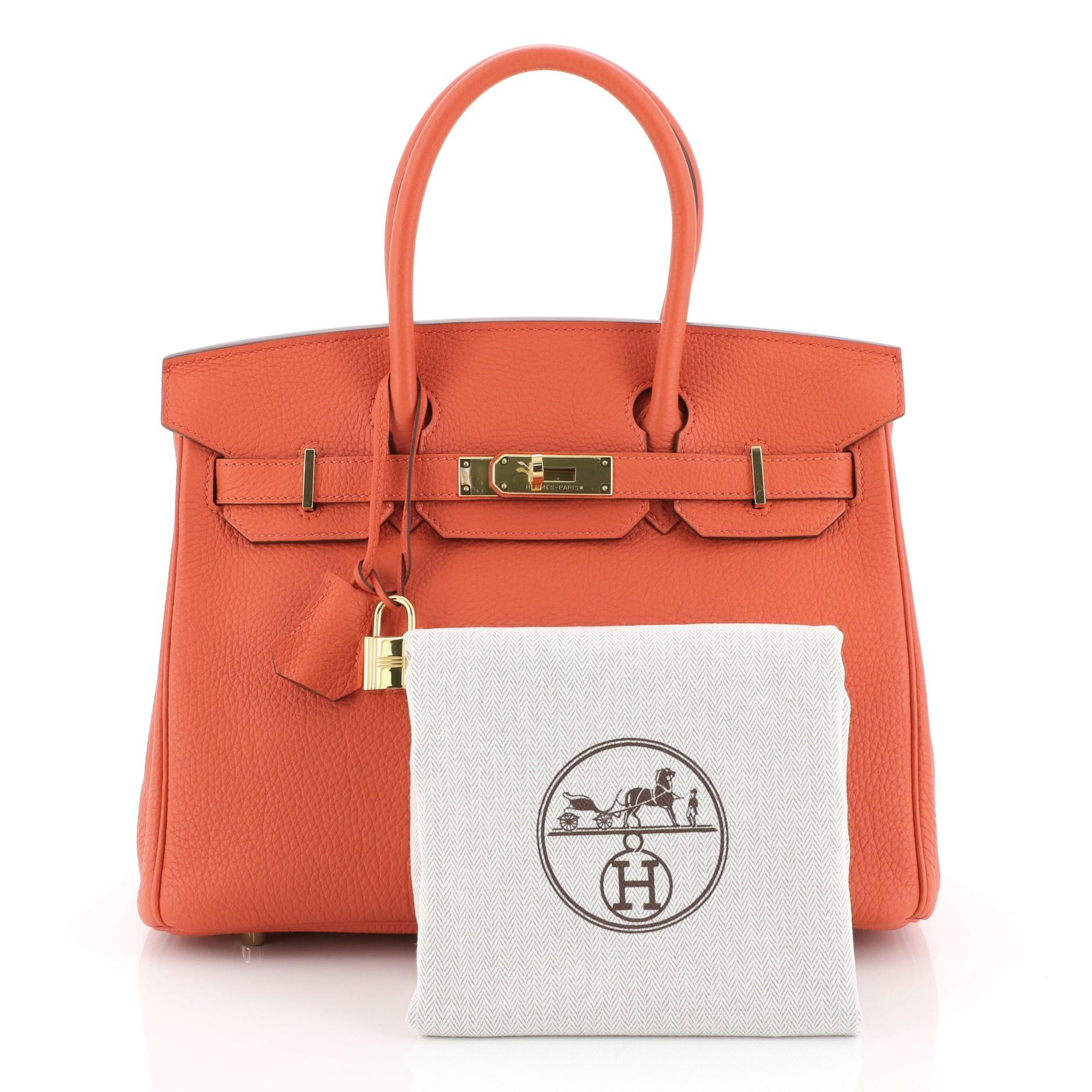 This Hermes Birkin Handbag Feu Togo with Gold Hardware 30, crafted in Feu orange Togo leather, features dual rolled handles, frontal flap, and gold hardware. Its turn-lock closure opens to a Feu orange Chevre leather interior with zip and slip