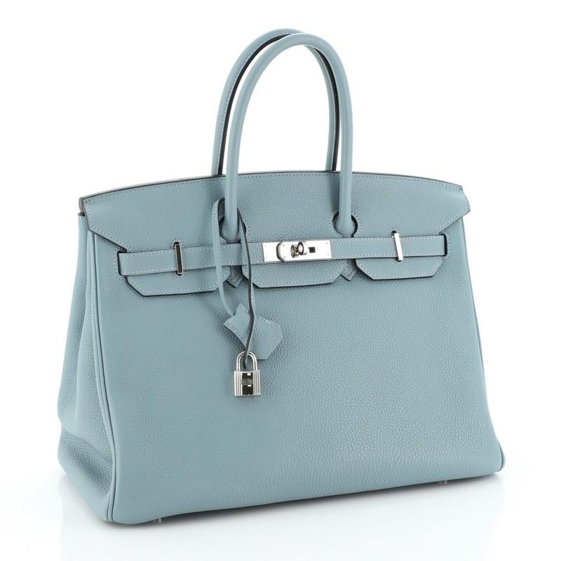 This Hermes Birkin Handbag Ciel Clemence with Palladium Hardware 35, crafted in Ciel blue Clemence leather, features dual rolled handles, frontal flap, and palladium hardware. Its turn-lock closure opens to a Ciel blue Chevre leather interior with