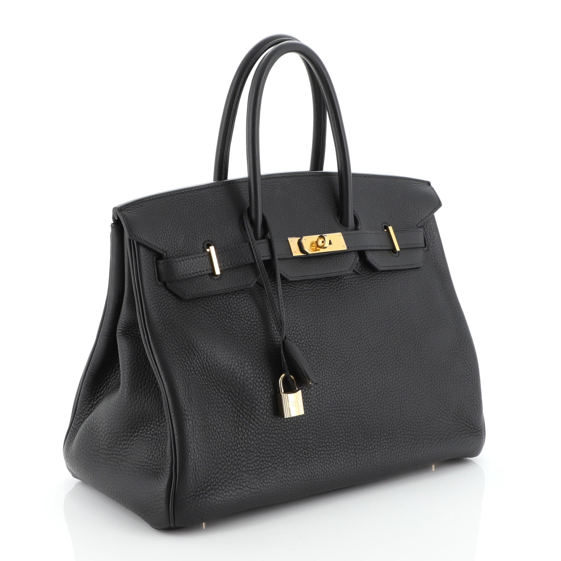 This Hermes Birkin Handbag Noir Togo with Gold Hardware 35, crafted in Noir black Togo leather, features dual rolled handles, frontal flap, and gold hardware. Its turn-lock closure opens to a Noir black Chevre leather interior with zip and slip