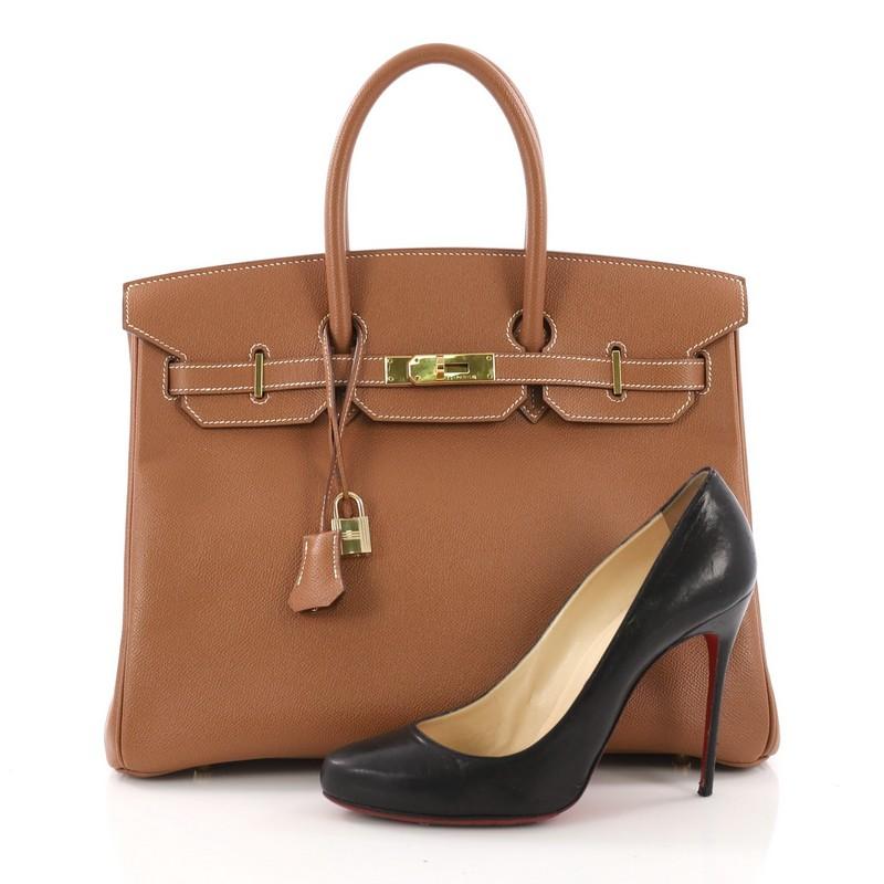 This Hermes Birkin Handbag Gold Courchevel with Gold Hardware 35, crafted in gold brown courchevel leather, features dual rolled handles, front flap and gold-tone hardware. Its turn-lock closure opens to a brown leather interior with slip and zip