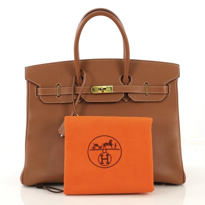 This Hermes Birkin Handbag Gold Epsom with Gold Hardware 35, crafted in Gold brown Epsom leather, features dual rolled handles, front flap and gold hardware. Its turn-lock closure opens to a Gold brown Chevre leather interior with slip and zip