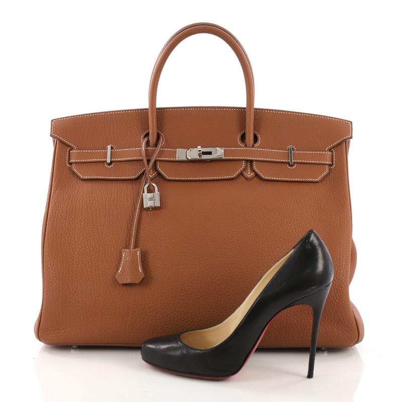This Hermes Birkin Handbag Gold Fjord with Palladium Hardware 40, crafted in Gold brown Fjord leather, features dual rolled handles, front flap, and Palladium hardware. Its turn-lock closure opens to a Gold brown Chevre leather interior with slip