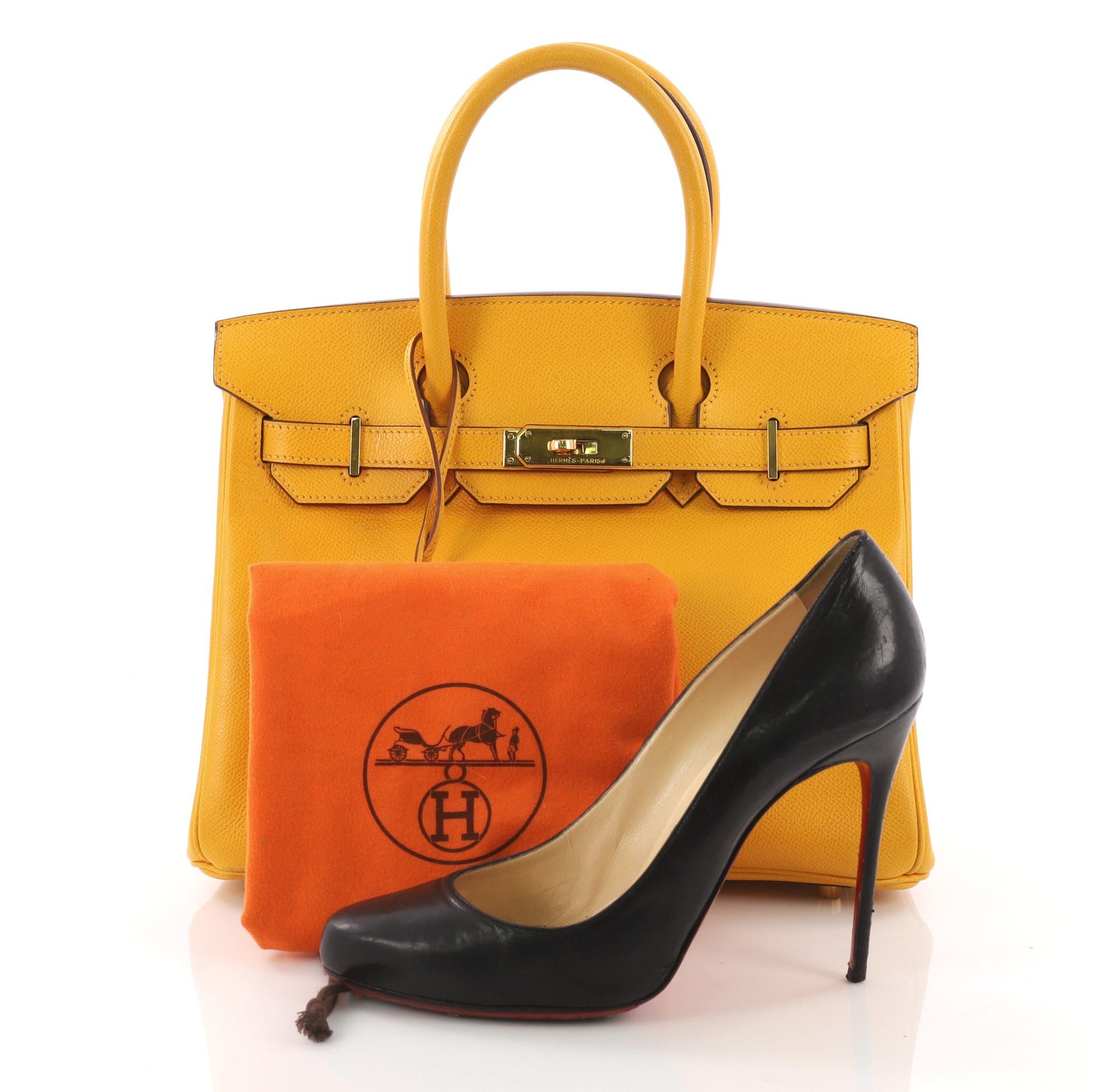 This Hermes Birkin Handbag Jaune Courchevel with Gold Hardware 30, crafted in Jaune yellow courchevel leather, features dual rolled handles, front flap and gold-tone hardware. Its turn-lock closure opens to a yellow leather interior with slip and