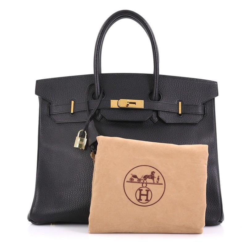 This Hermes Birkin Handbag Noir Ardennes with Gold Hardware 35, crafted in Noir black Ardennes leather, features dual rolled handles, frontal flap, and gold hardware. Its turn-lock closure opens to a Noir black Chevre leather interior with slip