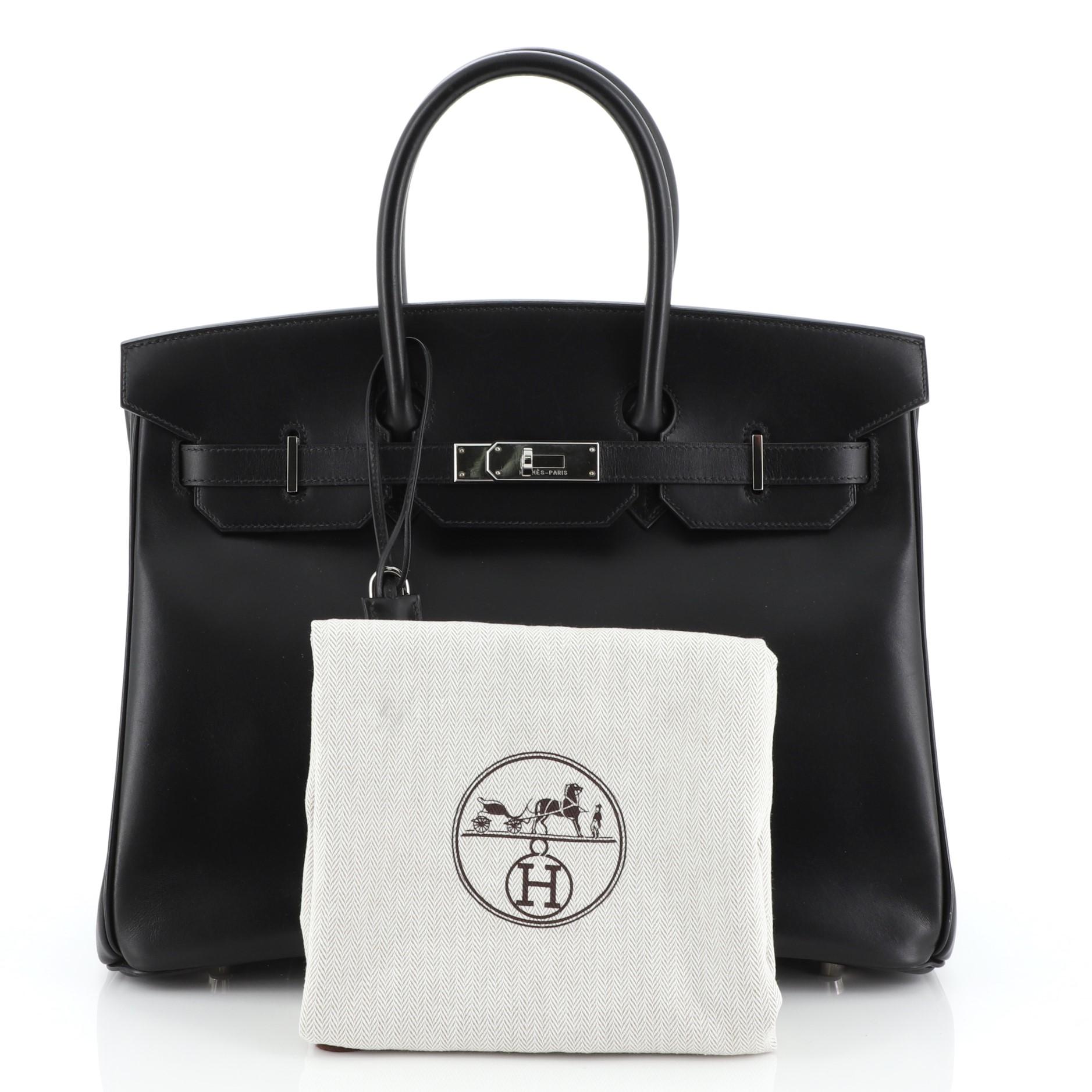This Hermes Birkin Handbag Noir Box Calf with Palladium Hardware 35, crafted in Noir black Box Calf leather, features dual rolled handles, frontal flap, and palladium hardware. Its turn-lock closure opens to a Noir black Chevre leather interior with