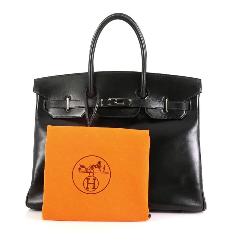 This Hermes Birkin Handbag Noir Box Calf with Palladium Hardware 35, crafted in Noir black Box Calf leather, features dual rolled handles, frontal flap, and ruthenium hardware. Its turn-lock closure opens to a Noir black Chevre leather interior with