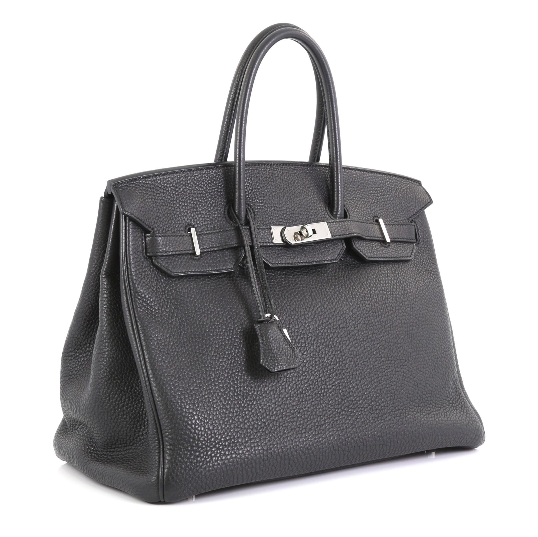 This Hermes Birkin Handbag Noir Clemence with Palladium Hardware 35, crafted in Noir black Clemence leather, features dual rolled handles, frontal flap, and palladium hardware. Its turn-lock closure opens to a Noir black Chevre leather interior with