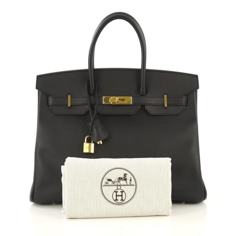 This Hermes Birkin Handbag Noir Epsom with Gold Hardware 35, crafted in Noir black Epsom leather, features dual rolled handles, frontal flap, and gold hardware. Its turn-lock closure opens to a Noir black Chevre leather interior with zip and slip