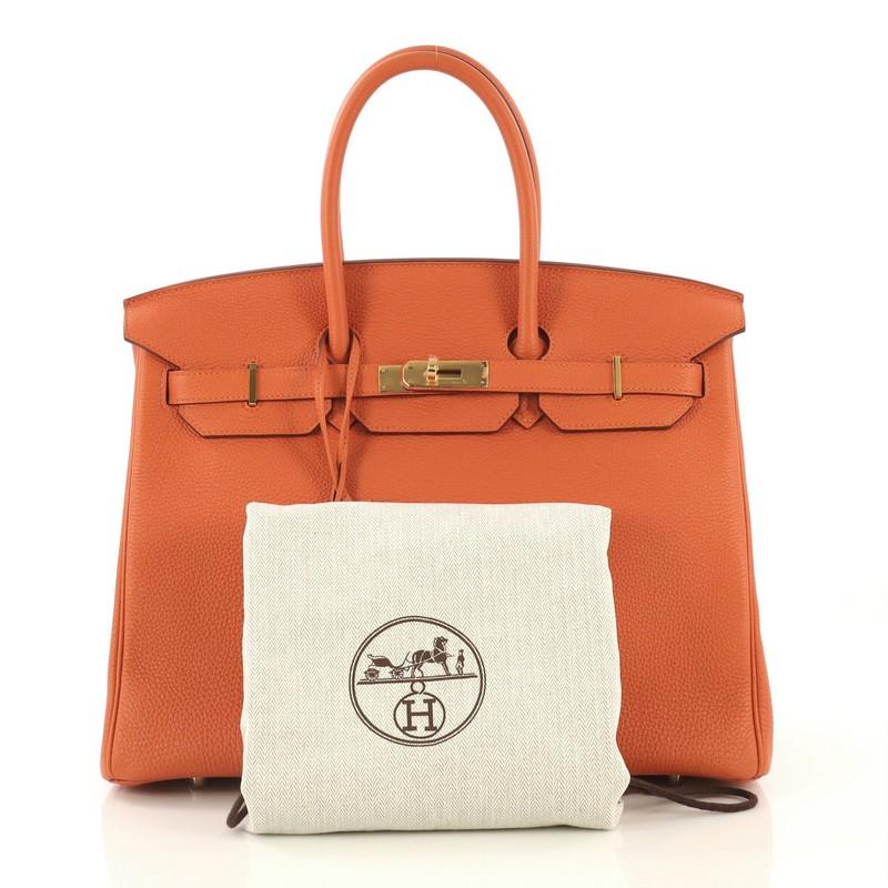 This Hermes Birkin Handbag Orange H Togo with Gold Hardware 35, crafted in Orange H orange Togo leather, features dual rolled handles, frontal flap, and gold hardware. Its turn-lock closure opens to an Orange H orange Chevre leather interior with