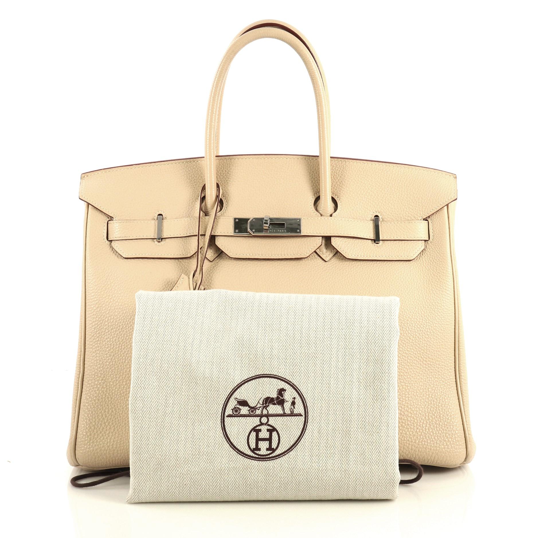This Hermes Birkin Handbag Parchemin Togo with Palladium Hardware 35, crafted in Parchemin neutral Togo leather, features dual rolled top handles, frontal flap, and palladium hardware. Its turn-lock closure opens to a Parchemin neutral Chevre