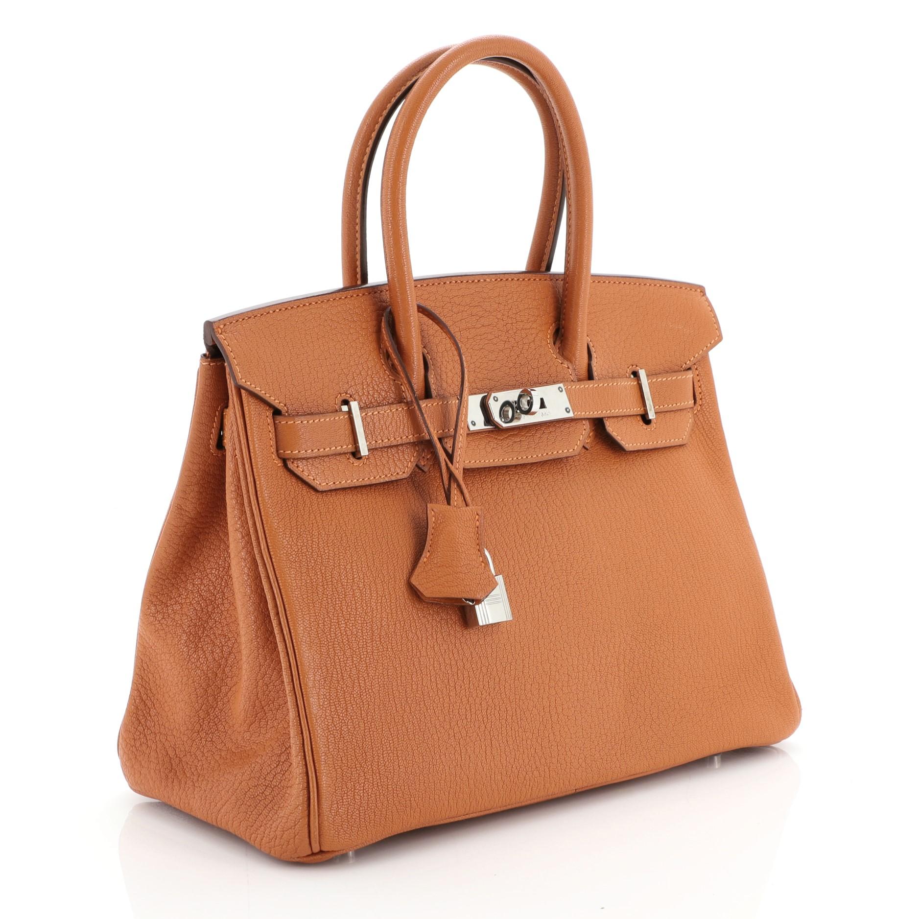 This Hermes Birkin Handbag Potiron Chevre de Coromandel with Palladium Hardware 30, crafted in Potiron Chevre de Coromandel leather, features dual rolled handles, frontal flap, and palladium hardware. Its turn-lock closure opens to a Potiron orange