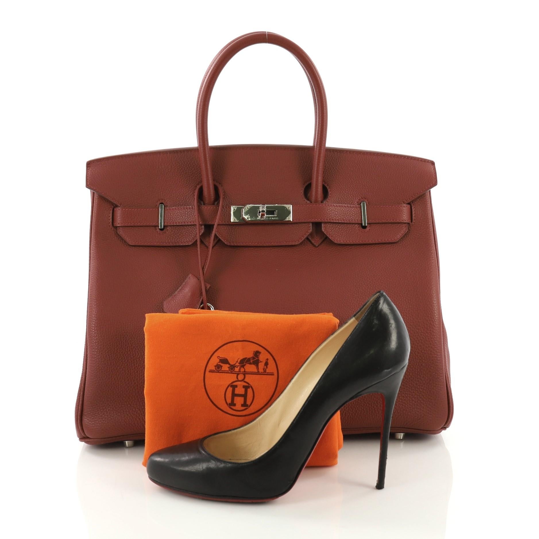 This Hermes Birkin Handbag Red Togo with Palladium Hardware 35, crafted in Sienne red leather, features dual rolled top handles, protective base studs, and palladium-tone hardware. Its turn-lock closure opens to a red leather interior with zip and