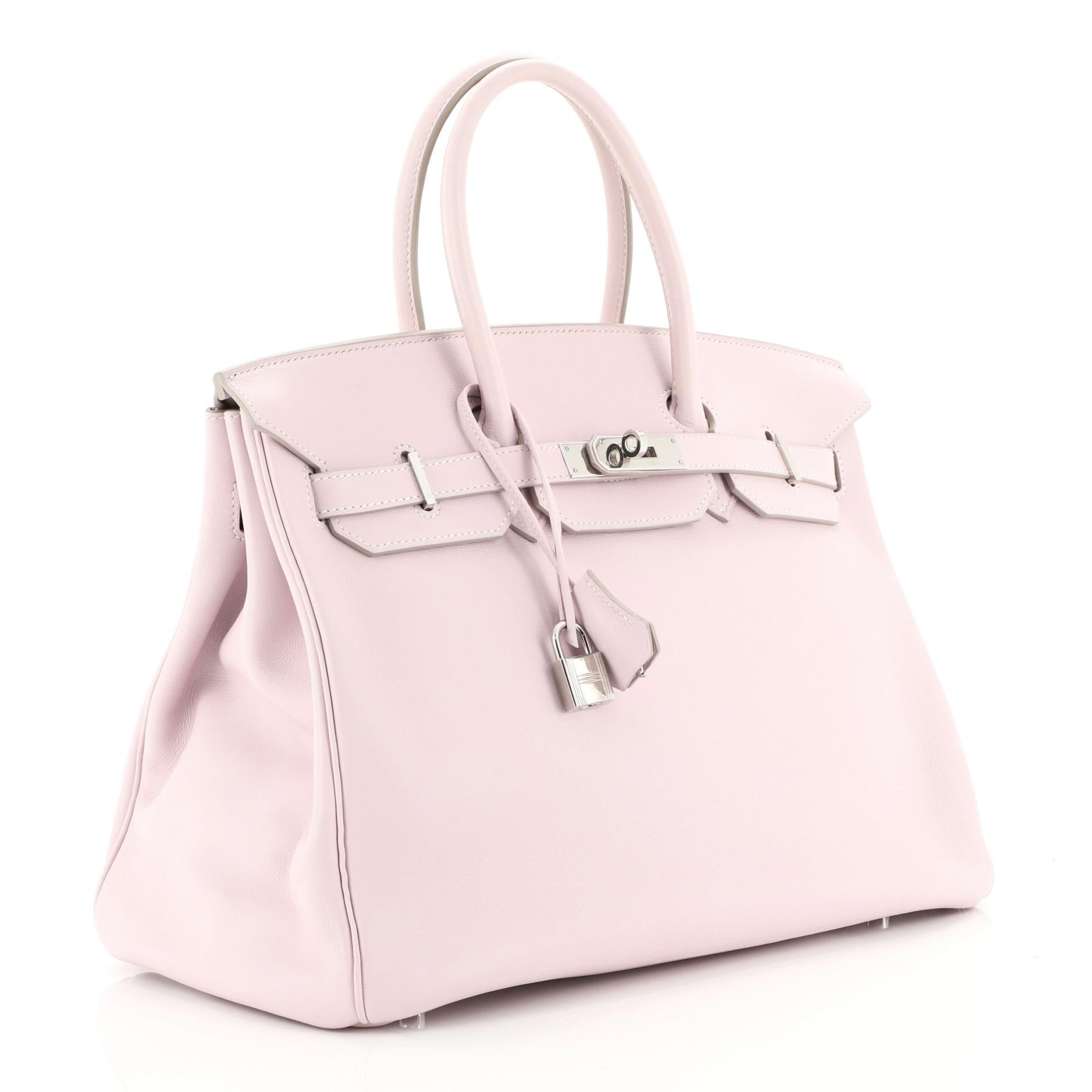 This Hermes Birkin Handbag Rose Dragee Swift with Palladium Hardware 35, crafted in Rose Dragee pink Swift leather, features dual rolled handles, frontal flap, and palladium hardware. Its turn-lock closure opens to a Rose Dragee pink Swift leather