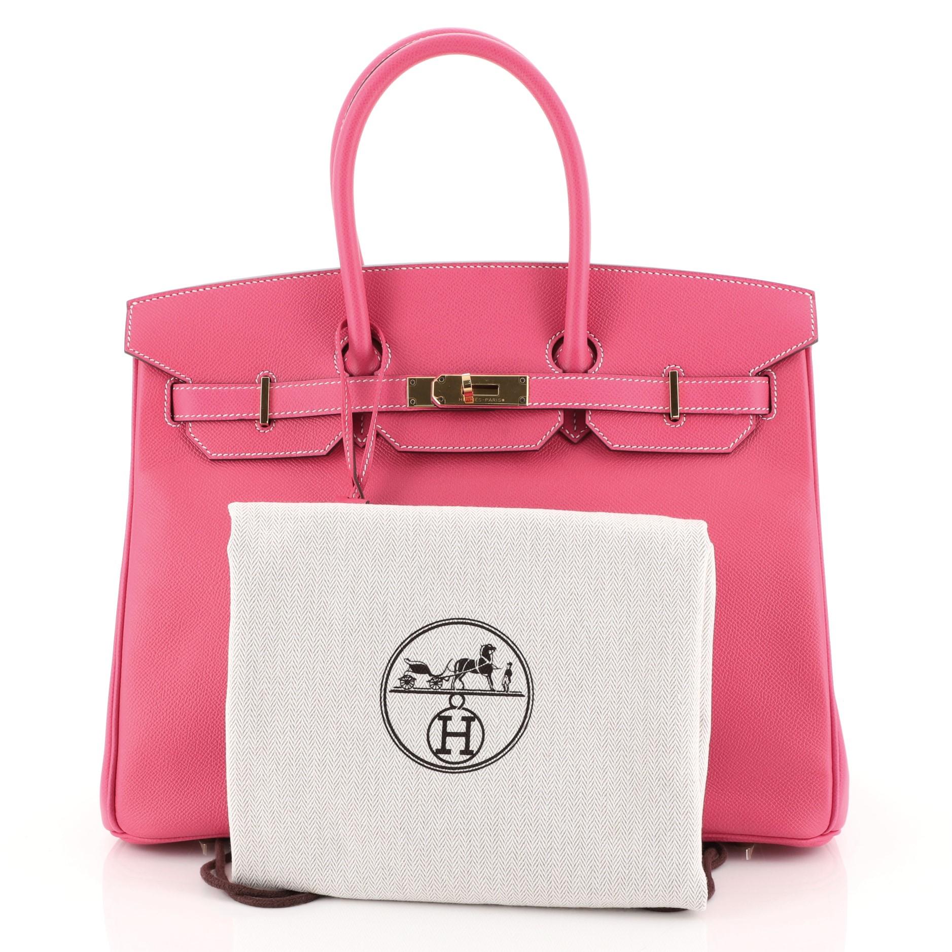 This Hermes Birkin Handbag Rose Tyrien Epsom with Gold Hardware 35, crafted in Rose Tyrien pink Epsom leather, features dual rolled handles, frontal flap, and gold hardware. Its turn-lock closure opens to a Rose Tyrien pink Chevre leather interior