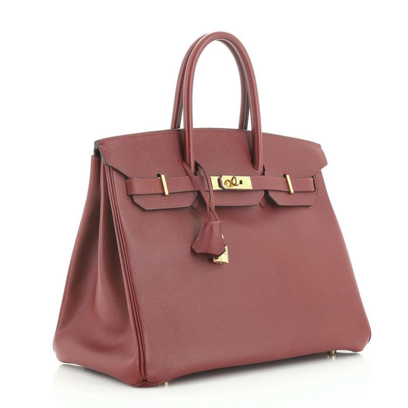 This Hermes Birkin Handbag Rouge H Courchevel with Gold Hardware 35, crafted in Rouge H red Courchevel leather, features dual rolled top handles, frontal flap, and gold hardware. Its turn-lock closure opens to a Rouge H red Chevre leather interior