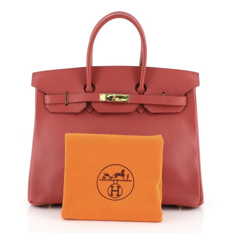 This Hermes Birkin Handbag Rouge Vif Ardennes with Gold Hardware 35, crafted in Rouge Vif red Ardennes leather, features dual rolled handles, frontal flap, and gold hardware. Its turn-lock closure opens to a Rouge Vif red Chevre leather interior