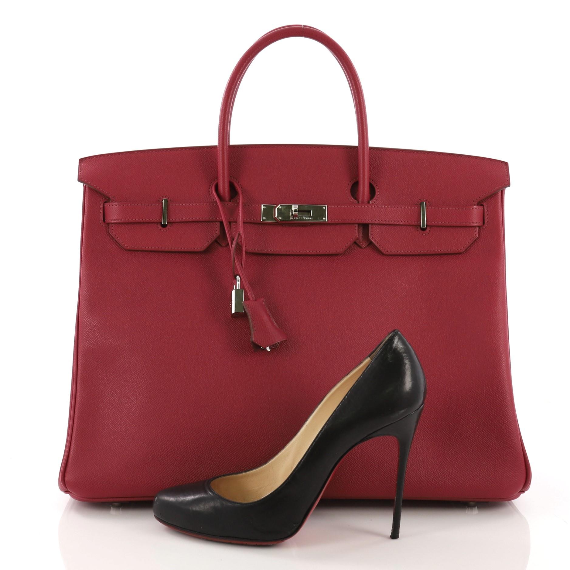 This Hermes Birkin Handbag Rubis Epsom with Palladium Hardware 40, crafted in Rubis red Epsom leather, features dual rolled handles, frontal flap, and palladium hardware. Its turn-lock closure opens to a Rubis red Chevre leather interior with slip