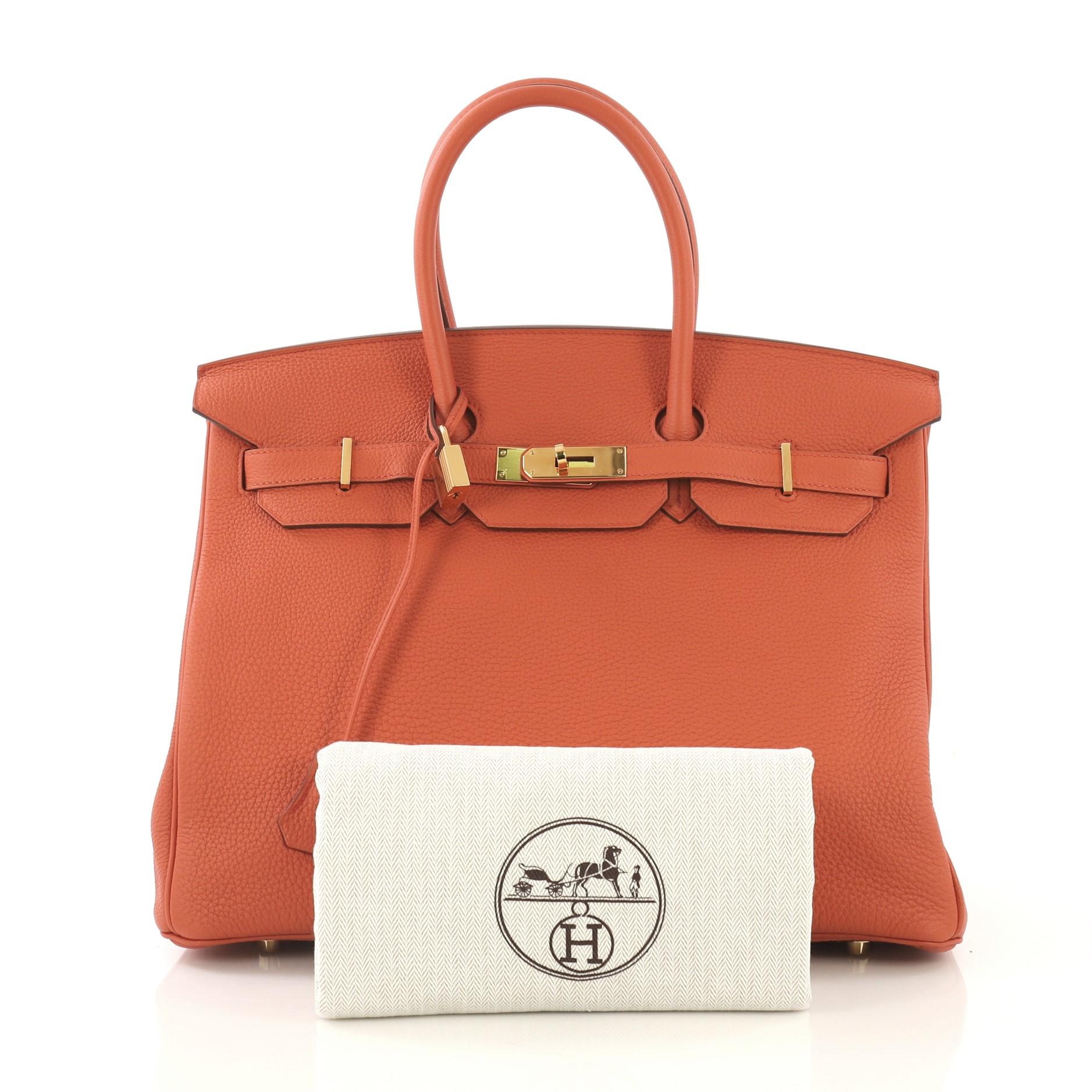 This Hermes Birkin Handbag Terre Battue Togo with Gold Hardware 35, crafted in Terre Battue orange Togo leather, features dual rolled handles, frontal flap, and gold hardware. Its turn-lock closure opens to a Terre Battue orange Chevre leather