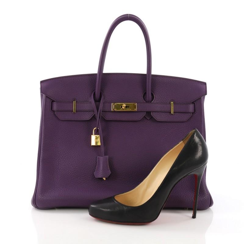 This Hermes Birkin Handbag Ultraviolet Clemence with Gold Hardware 35, crafted in Ultraviolet purple Clemence leather, features dual rolled top handles, protective base studs, and gold hardware. Its turn-lock closure opens to a Ultraviolet purple
