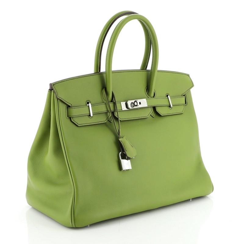 This Hermes Birkin Handbag Vert Anis Swift with Palladium Hardware 35, crafted in Vert Anis green Swift leather, features dual rolled handles, frontal flap, and palladium hardware. Its turn-lock closure opens to a Vert Anis green Swift leather