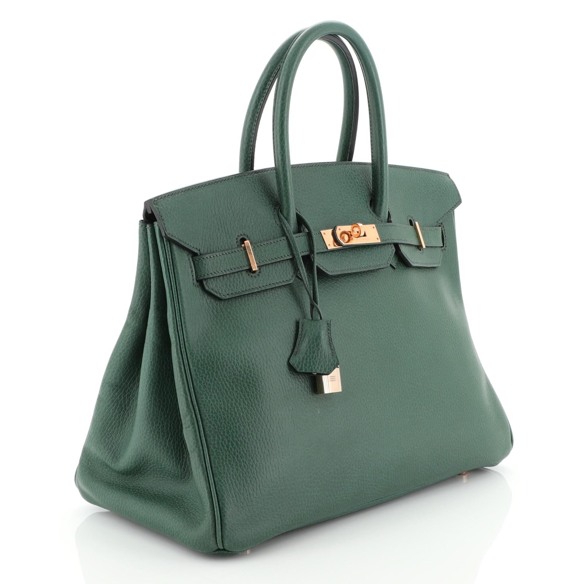 This Hermes Birkin Handbag Vert Clair Ardennes with Gold Hardware 35, crafted in Vert Clair green Ardennes leather, features dual rolled handles, front flap, and gold hardware. Its turn-lock closure opens to a Vert Clair green Chevre leather