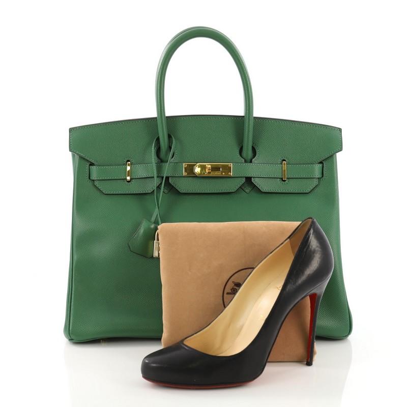 This Hermes Birkin Handbag Vert Clair Courchevel with Gold Hardware 35, crafted in Vert Clair green Courchevel leather, features dual rolled top handles, protective base studs, and gold-tone hardware. Its turn-lock closure opens to a green chevre