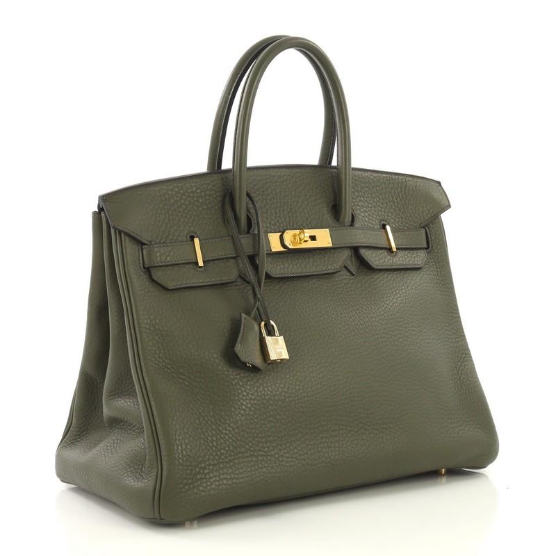 This Hermes Birkin Handbag Vert Olive Clemence with Gold Hardware 35, crafted in Vert Olive green leather, features dual rolled handles, frontal flap, and gold hardware. Its turn-lock closure opens to a Vert Olive green Chevre leather interior with