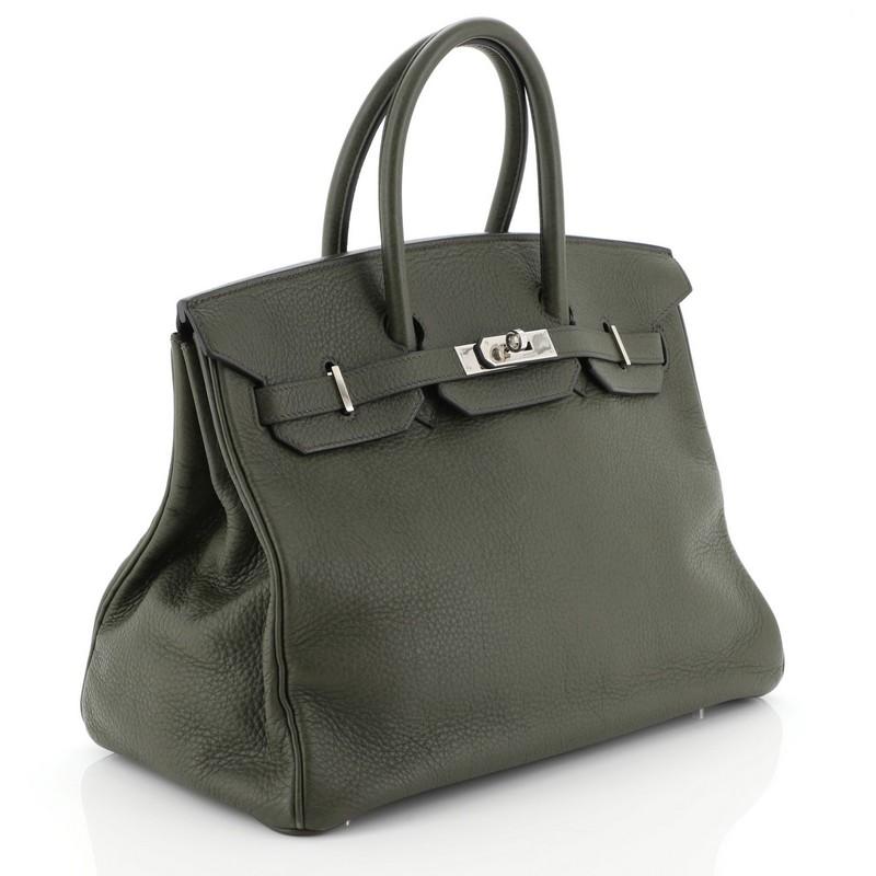 This Hermes Birkin Handbag Vert Olive Clemence with Palladium Hardware 35, crafted in Vert Olive green Clemence leather, features dual rolled handles, frontal flap, and palladium hardware. Its turn-lock closure opens to a Vert Olive green Chevre