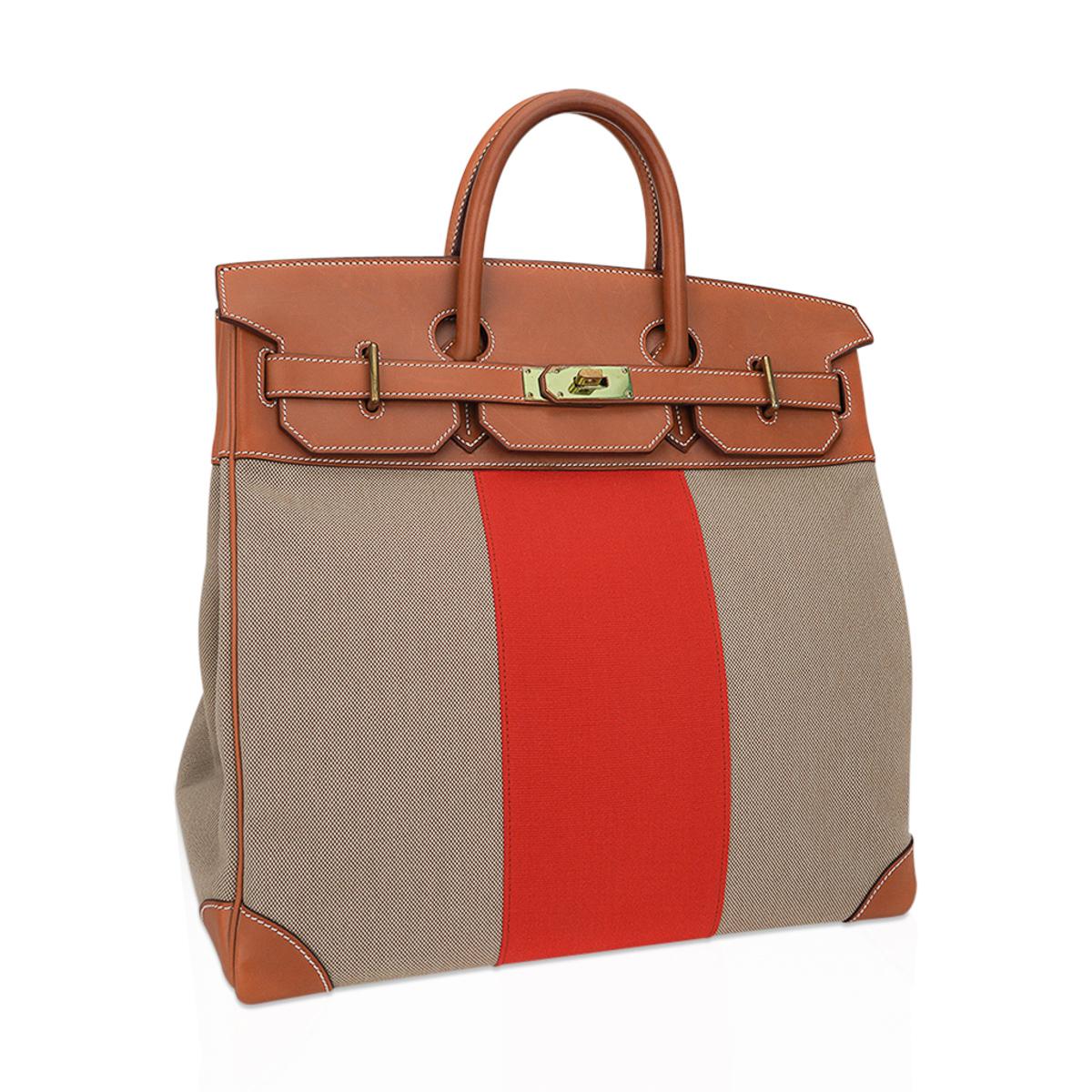 Mightychic offers a  rare limited edition Hermes HAC 40 Flag bag.
Coveted Barenia leather and Ficelle Hermes signature Toile.
Beautifully detailed with the paprika orange wide stripe it is neutral perfection for everyday to travel wear.
This Hermes