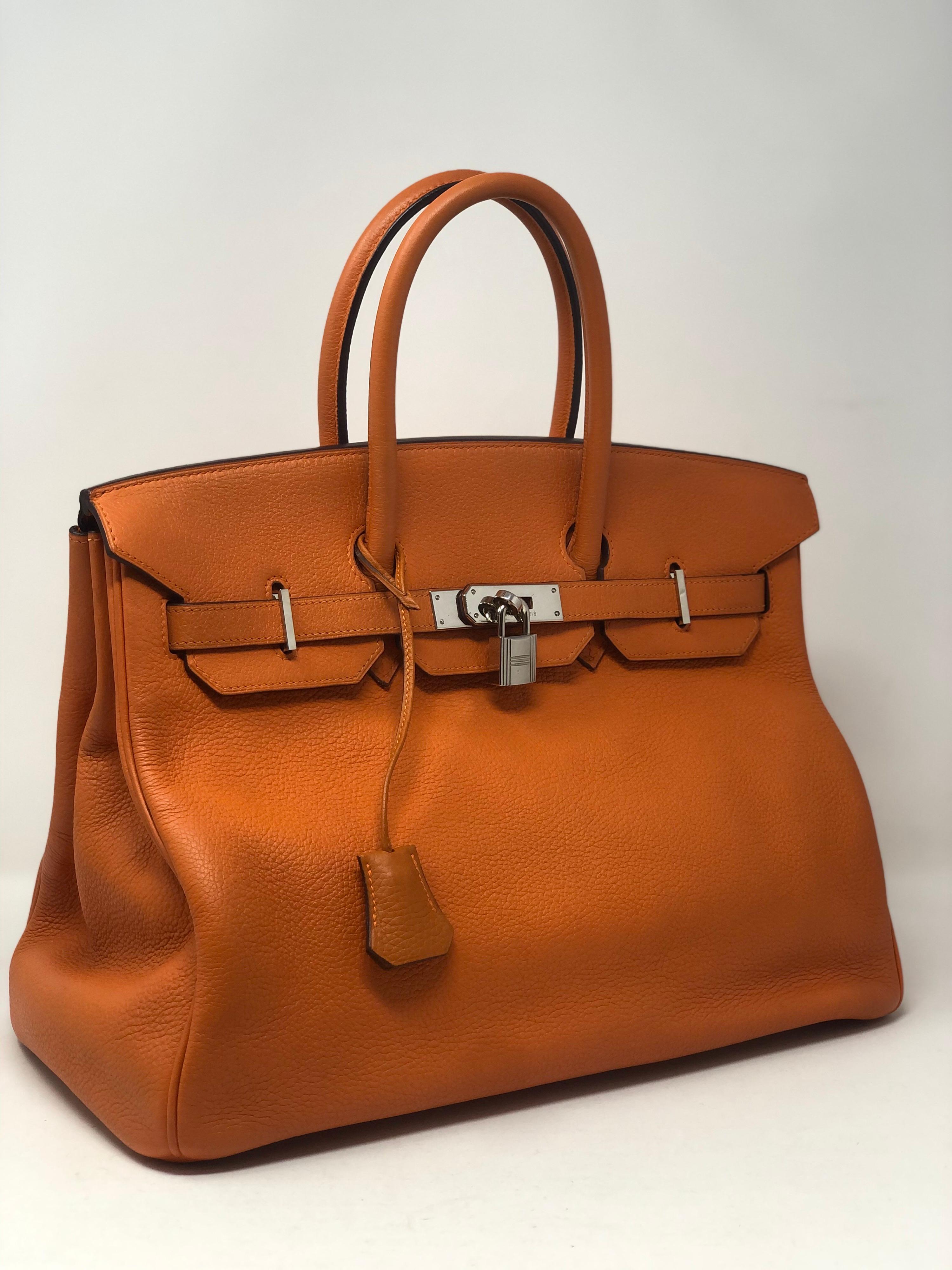 Hermes Birkin 35 Orange Bag. Palladium hardware. Classic orange color in clemence leather. Slight slouch from wear. Includes clochette, lock, keys, and dust cover. Guaranteed authentic. 