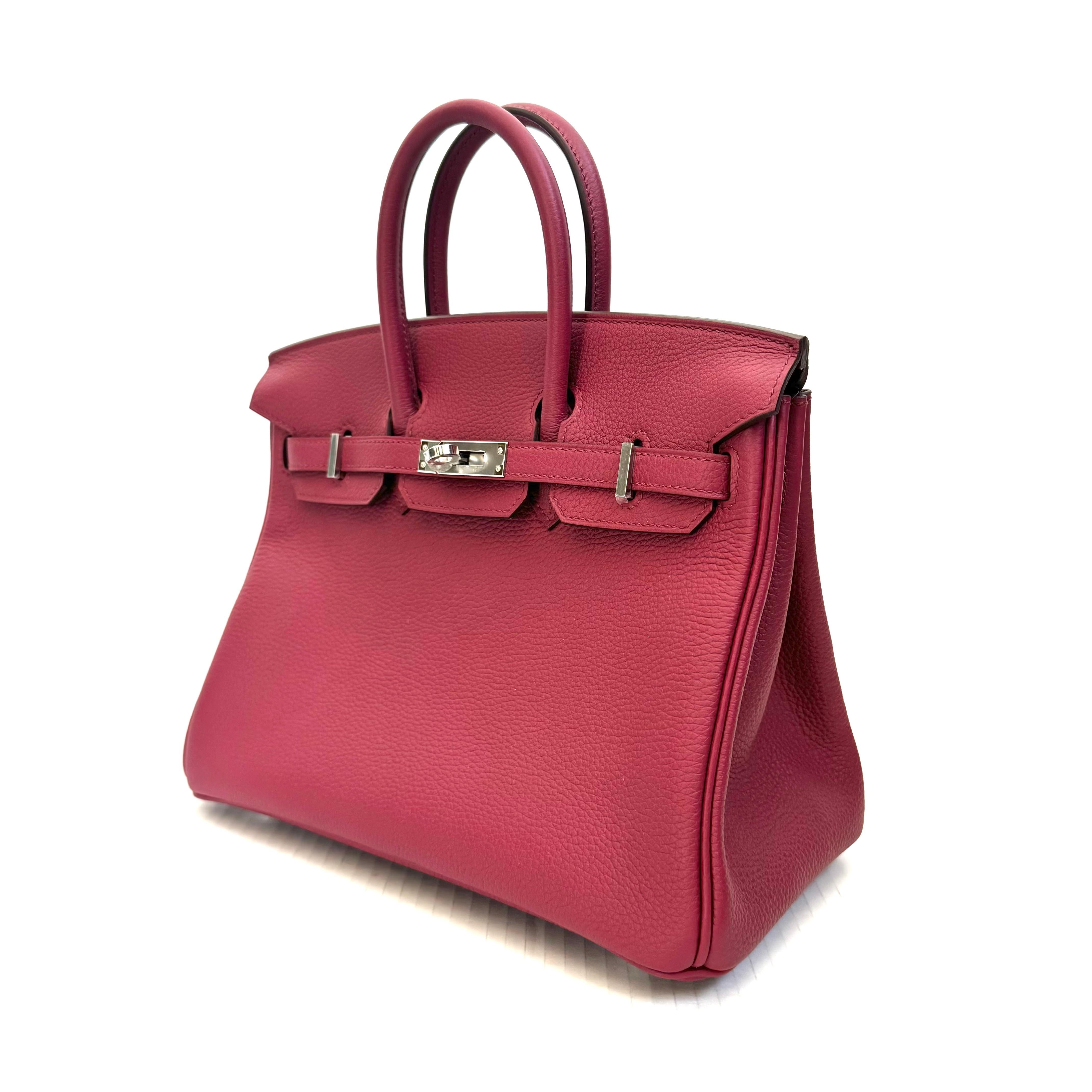 Gorgeous, authentic Hermès 25cm Birkin in Rouge. BRAND NEW, NEVER WORN, and unused condition. Plastic still on the feet/metal pieces throughout. Dark pink togo leather with silver hardware. Features the iconic dual-belt turnstile lock closure. 25cm