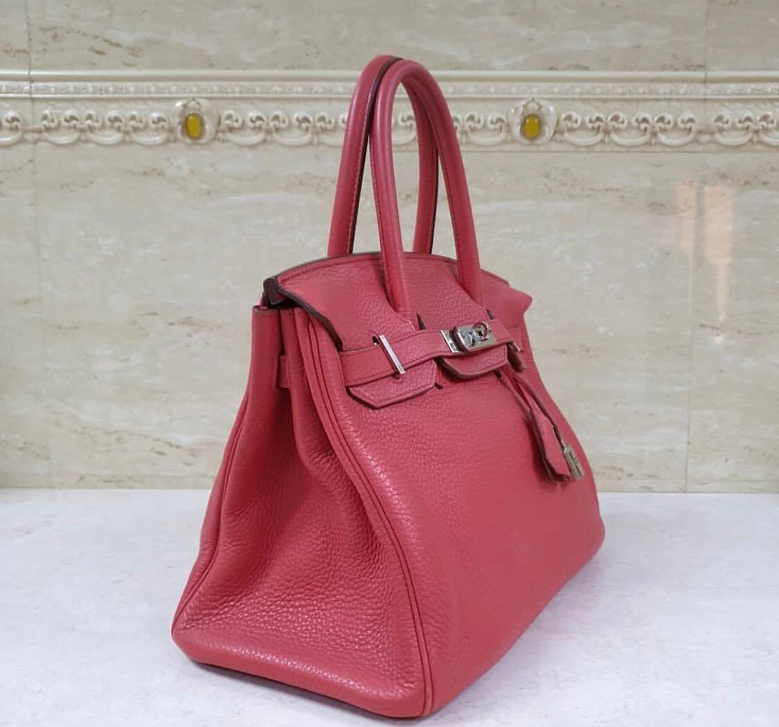 This authentic Hermès Ruby Togo 30 cm Birkin is pristine, appearing gently worn.

Togo is highly desirable scratch resistant calf leather; it is textured with a grainy appearance.  
Togo is soft to the hand and maintains the shape of the bag well