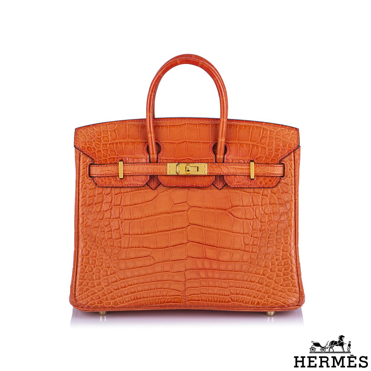 Una rara e squisita borsa Hermès Birkin da 25 cm. L'esterno di questa Birkin è in pelle di alligatore Mississippiensis arancione con finiture dorate. L'esterno è completo di cuciture tonali, due cinturini con chiusura frontale ad alamari e doppi