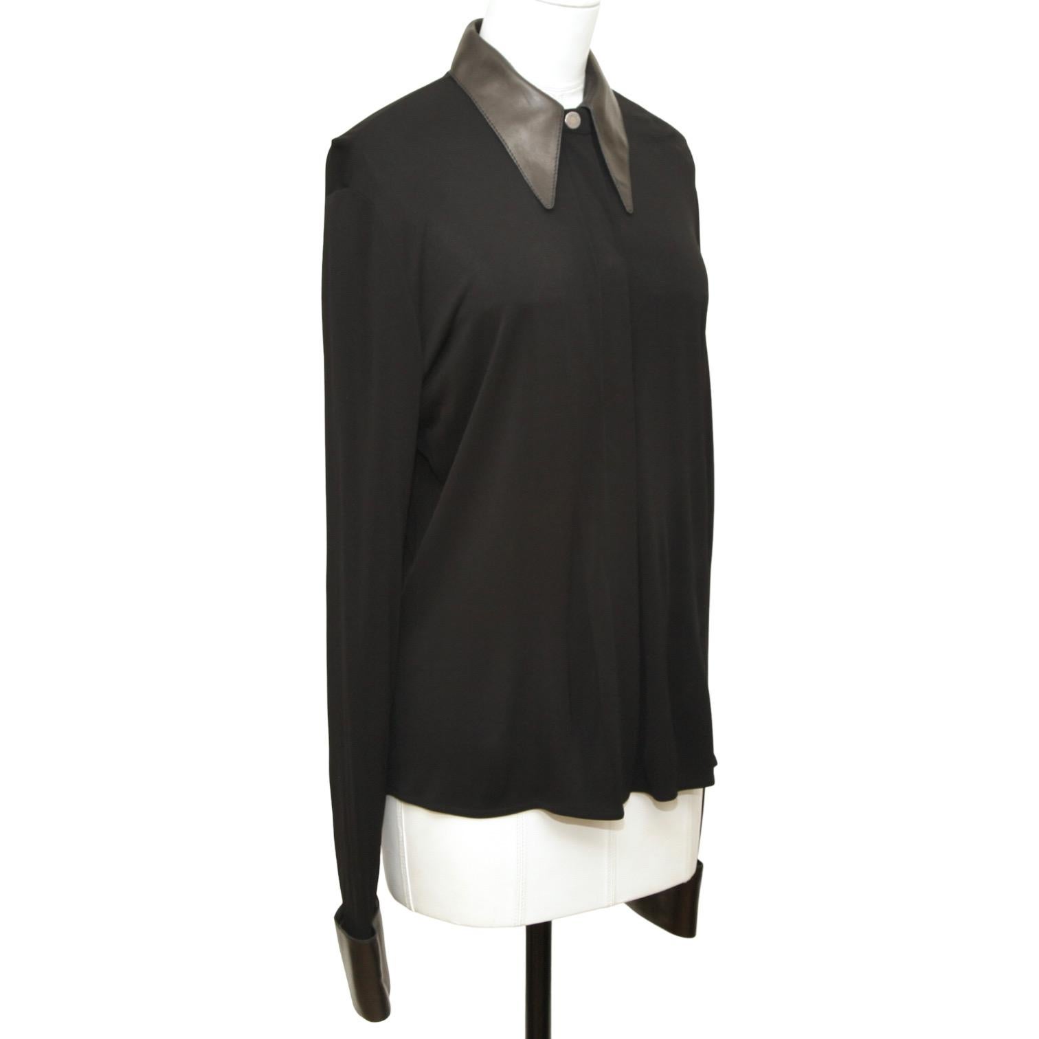 GUARANTEED AUTHENTIC VINTAGE HERMES BLACK LONG SLEEVE  BLOUSE

Design:
- Long sleeve black blouse.
- Black leather pointed collar and cuffs.
- Covered palladium silver button closure.

Material: 100% Viscose

Size: 42

Measurements (Approximate laid