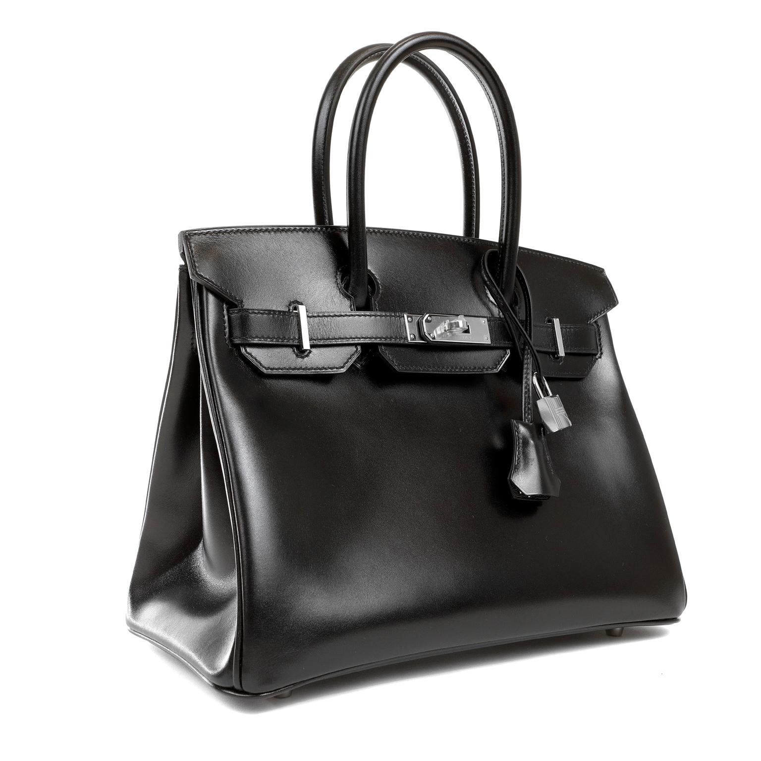This authentic Hermès Black Box Calf 30 cm Birkin is in pristine unworn condition with the protective plastic intact on the hardware. Each Hermès piece is sewn by hand and waitlists often exceed a year. The highly sought after Birkin is a rare find
