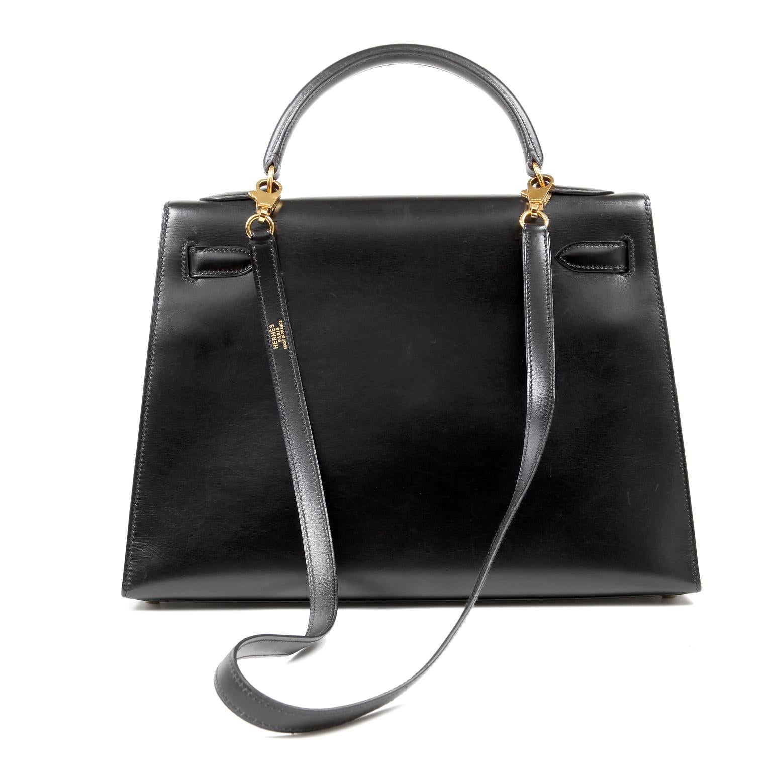 This authentic Hermès Black Box Calf 32 cm Kelly is in truly mint condition.  Hermès bags are considered the ultimate luxury item worldwide.  Each piece is handcrafted with waitlists that can exceed a year or more.  The ladylike Kelly is classic and
