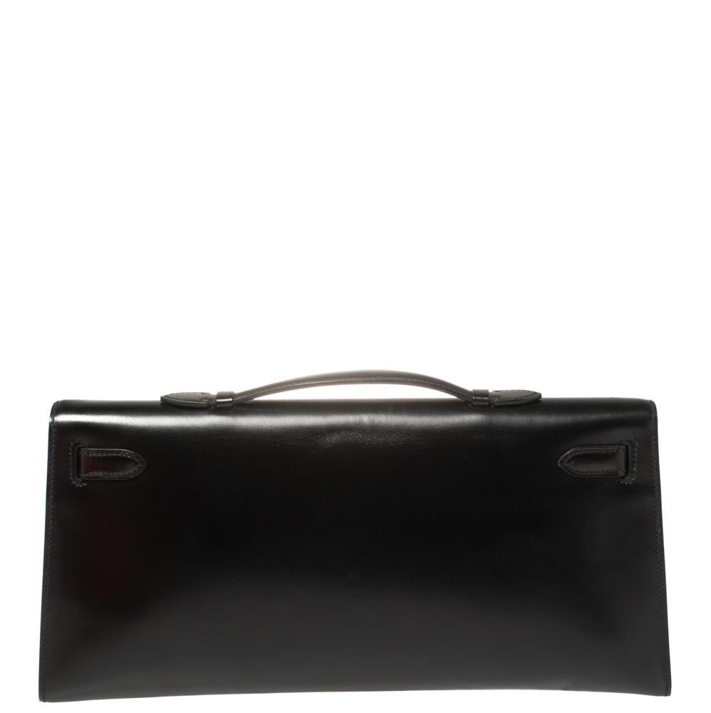 This Kelly clutch is carefully stitched to perfection. Crafted from Box Calf leather, it has a slim silhouette that’s easy to carry. The clutch has palladium hardware that forms the signature Kelly lock closure and a leather-lined interior that will