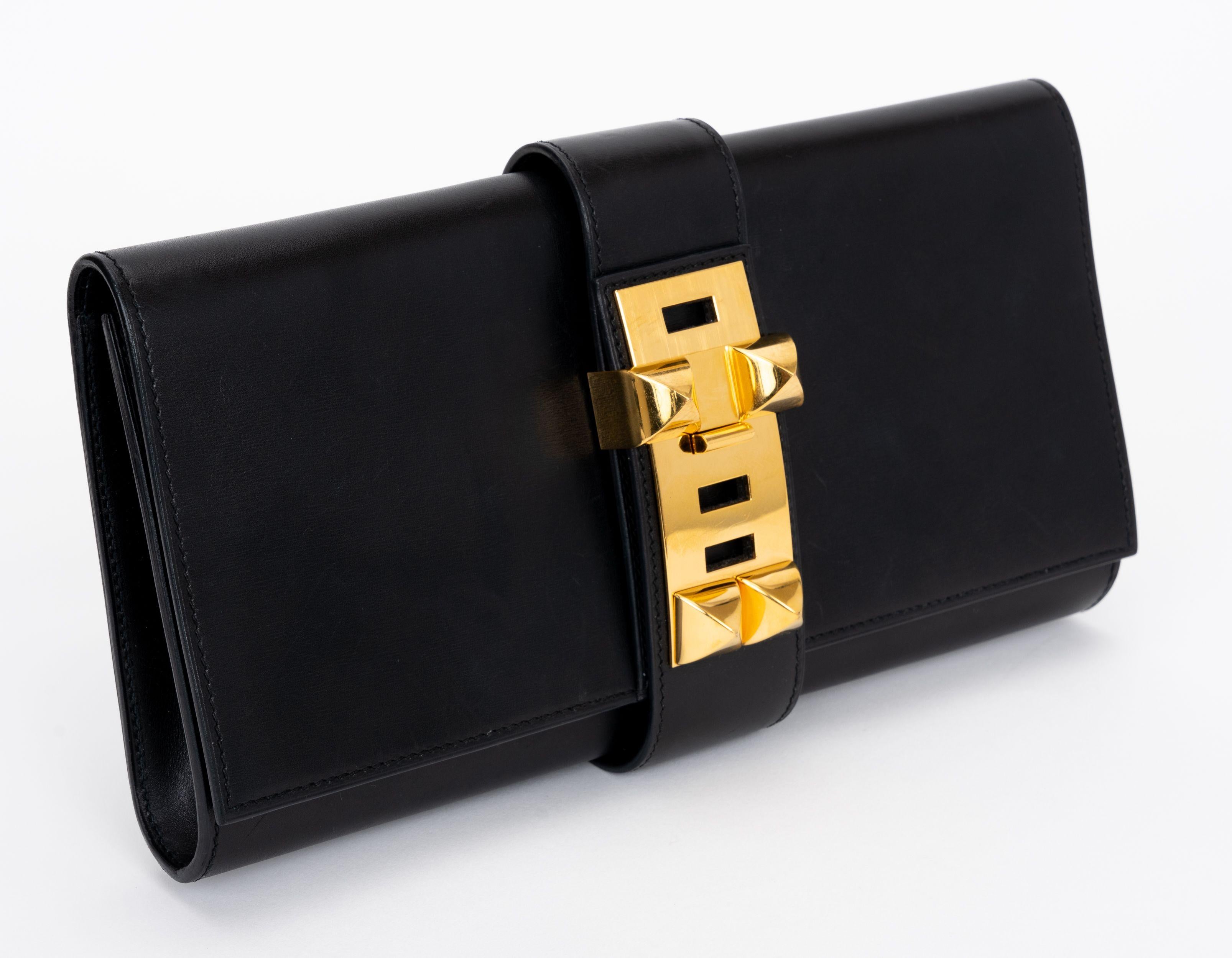The Hermes Box calf clutch features calfskin leather, a frontal flap and gold-plated studded hardware. One patch pocket in the interior. Date stamp J.original dust cover.