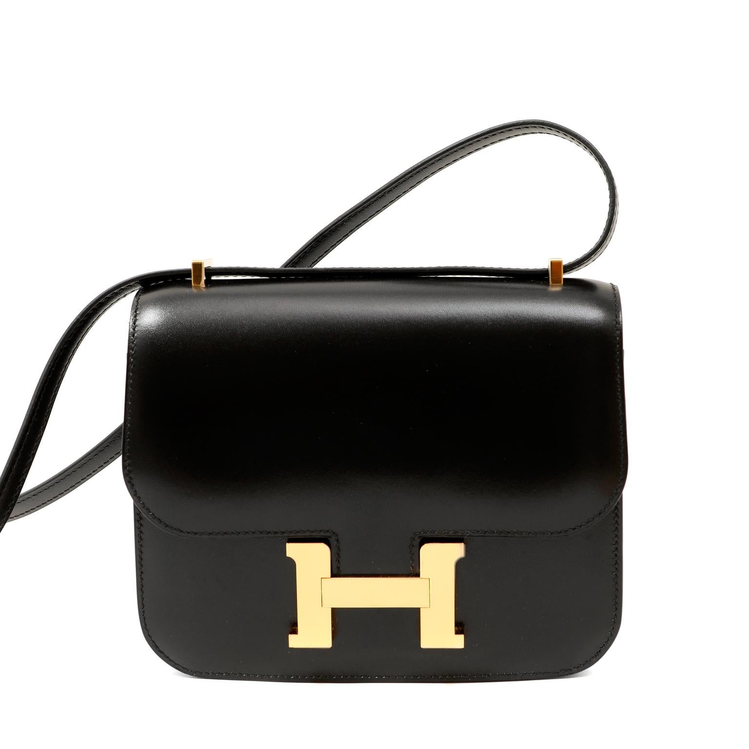 This authentic Hermès Black Box Calf Mini Constance in pristine unworn condition with the protective plastic intact on the hardware. 
The Constance has simple clean lines and combines classic with modern.  The adjustable strap allows for shoulder or