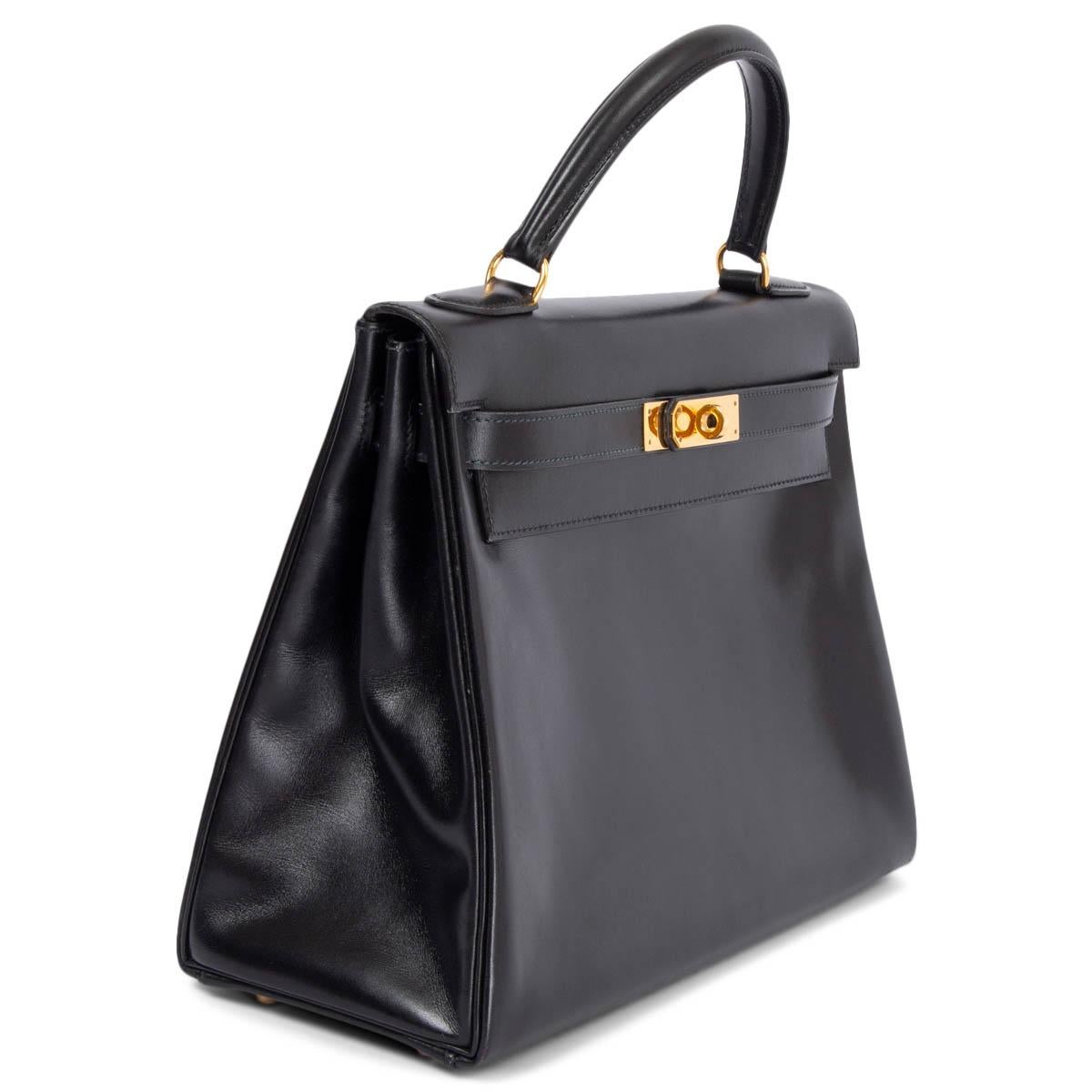 100% authentic Hermès Kelly 32 Retoune bag in black Veau Box leather featuring gold-tone hardware. Lined in Chevre (goat skin) with two open pockets against the front and a zipper pocket against the back. Comes with leather shoulder-strap. Has been