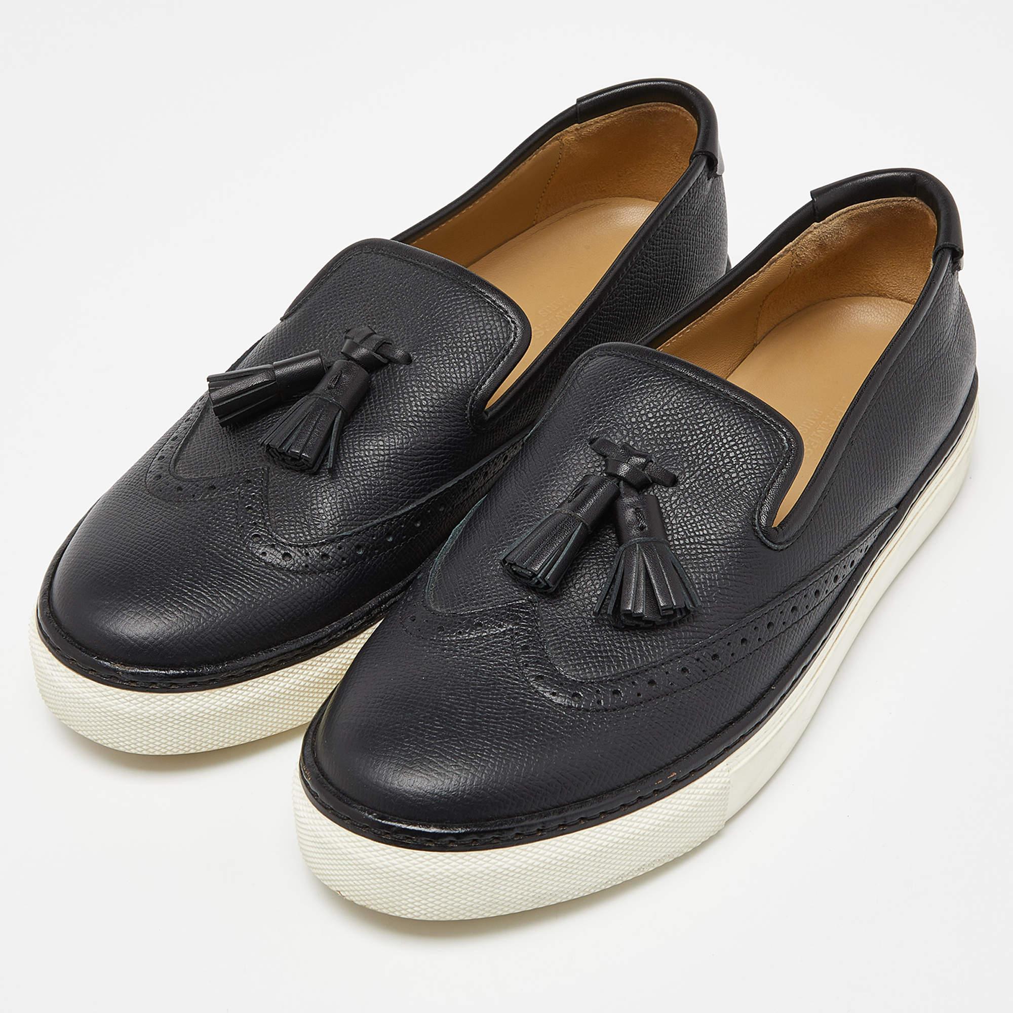 The Hermès sneakers exude sophistication with their premium black leather and meticulous brogue detailing. Featuring a stylish tassel accent, these sneakers seamlessly blend formal and casual elements, providing a luxurious and versatile footwear
