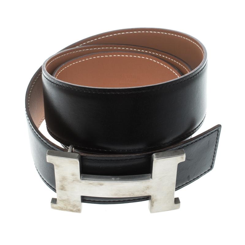 A classic add-on to your collection of belts, this Hermes piece has been crafted from leather. It is reversible with a black shade on one side and brown on the other. It is topped with an H buckle in silver-tone. This wardrobe essential piece will