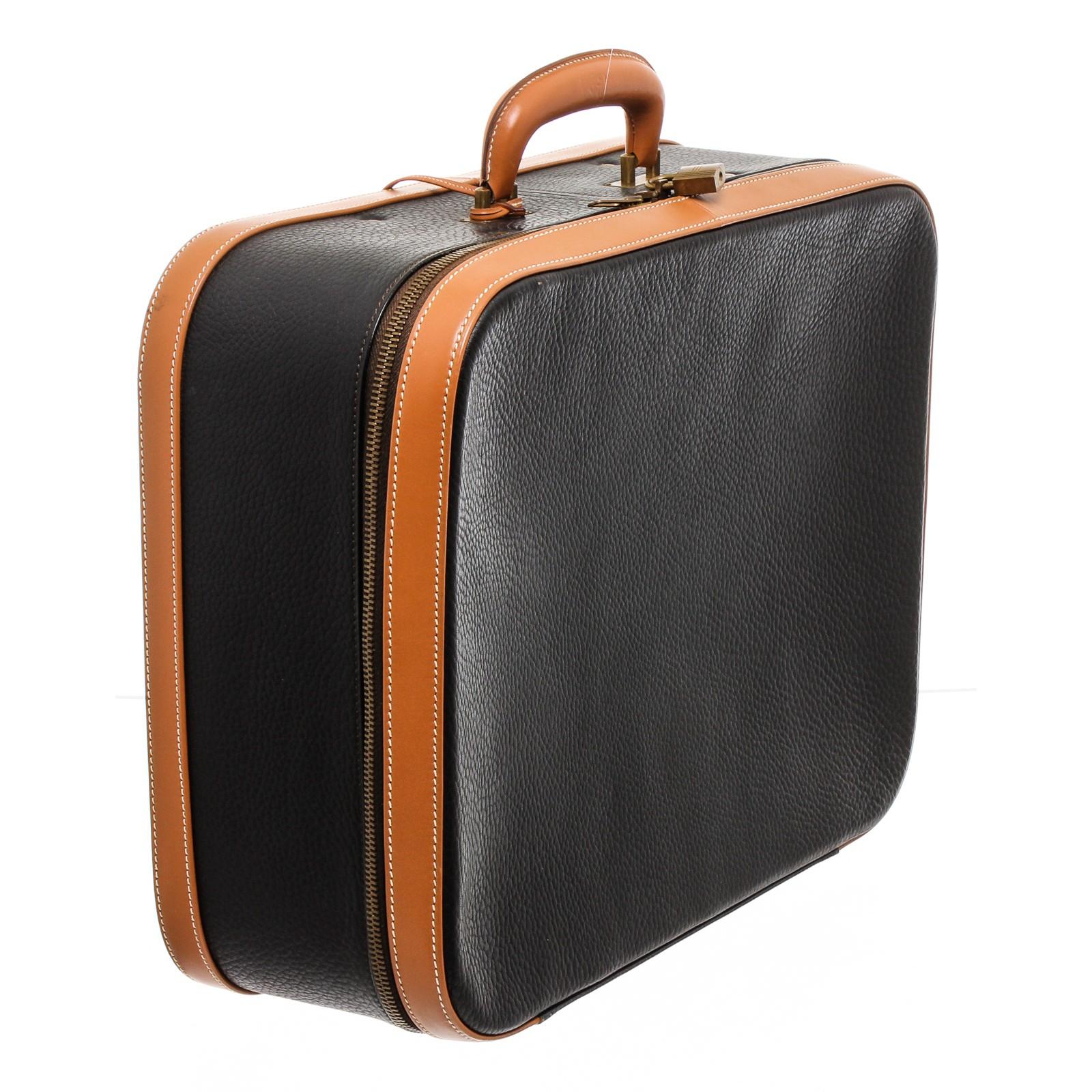 Hermes black pebbled leather suitcase with brown trim, brass colored hardware with lock and keys, cream brushed cotton interior lining, dual leather interior straps and divider, two way zippered closure. 16214MSC.