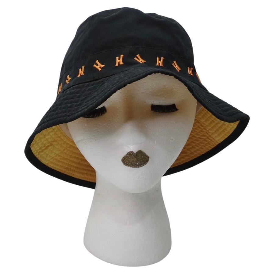 Classic vintage Black Hermes bucket hat with orange 'H' logos lining the base. Made from a lightweight polyester blend, this hat can match with just about anything and is ideal for any time of year. In a style that's almost a cross between a bucket