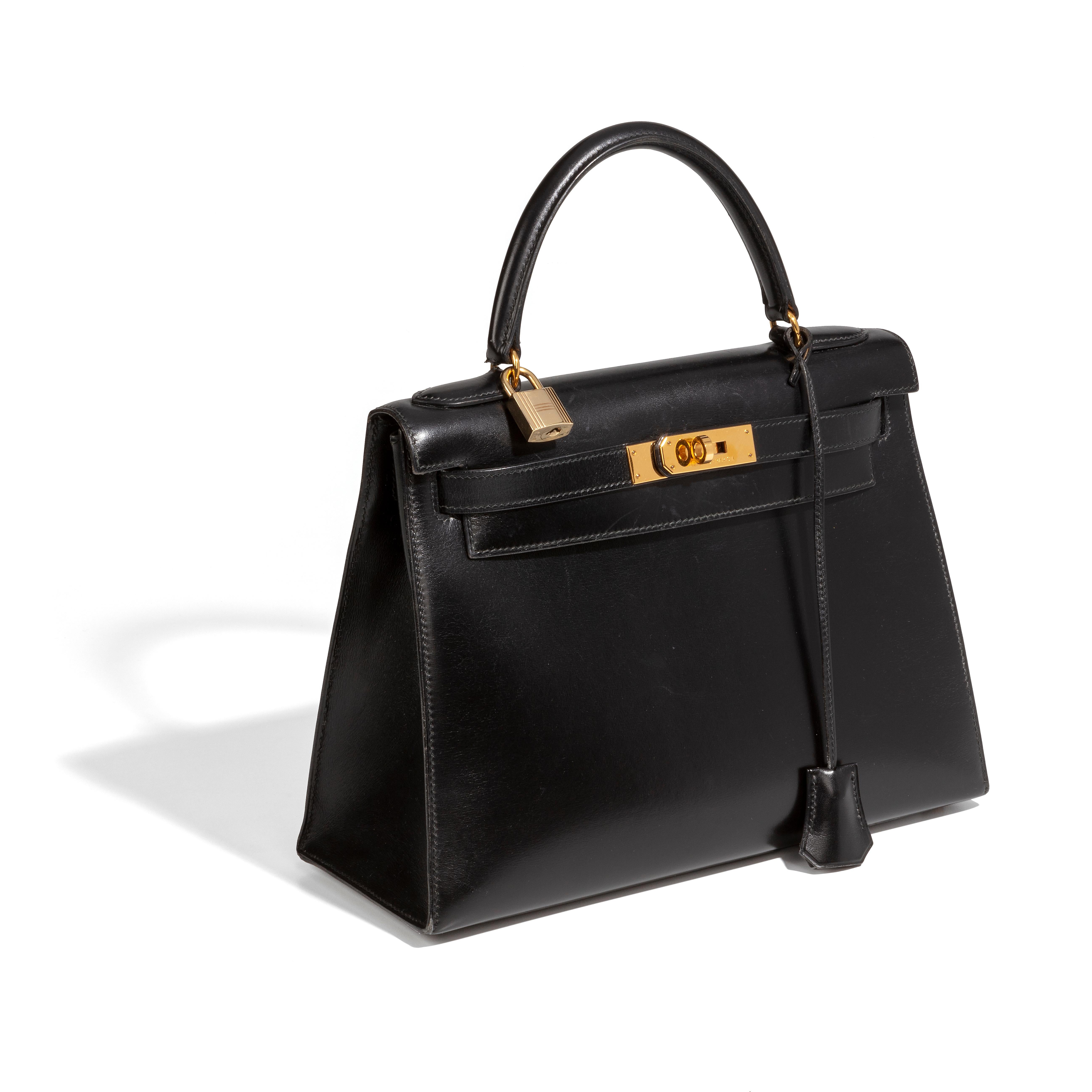 This black 28cm Kelly bag from Hermès is a true testament to the quality of the house's craftsmanship, exuding timeless style and elegance, perfect for any occasion with Box Calf leather and beautiful brushed palladium gold-tone hardware. The piece