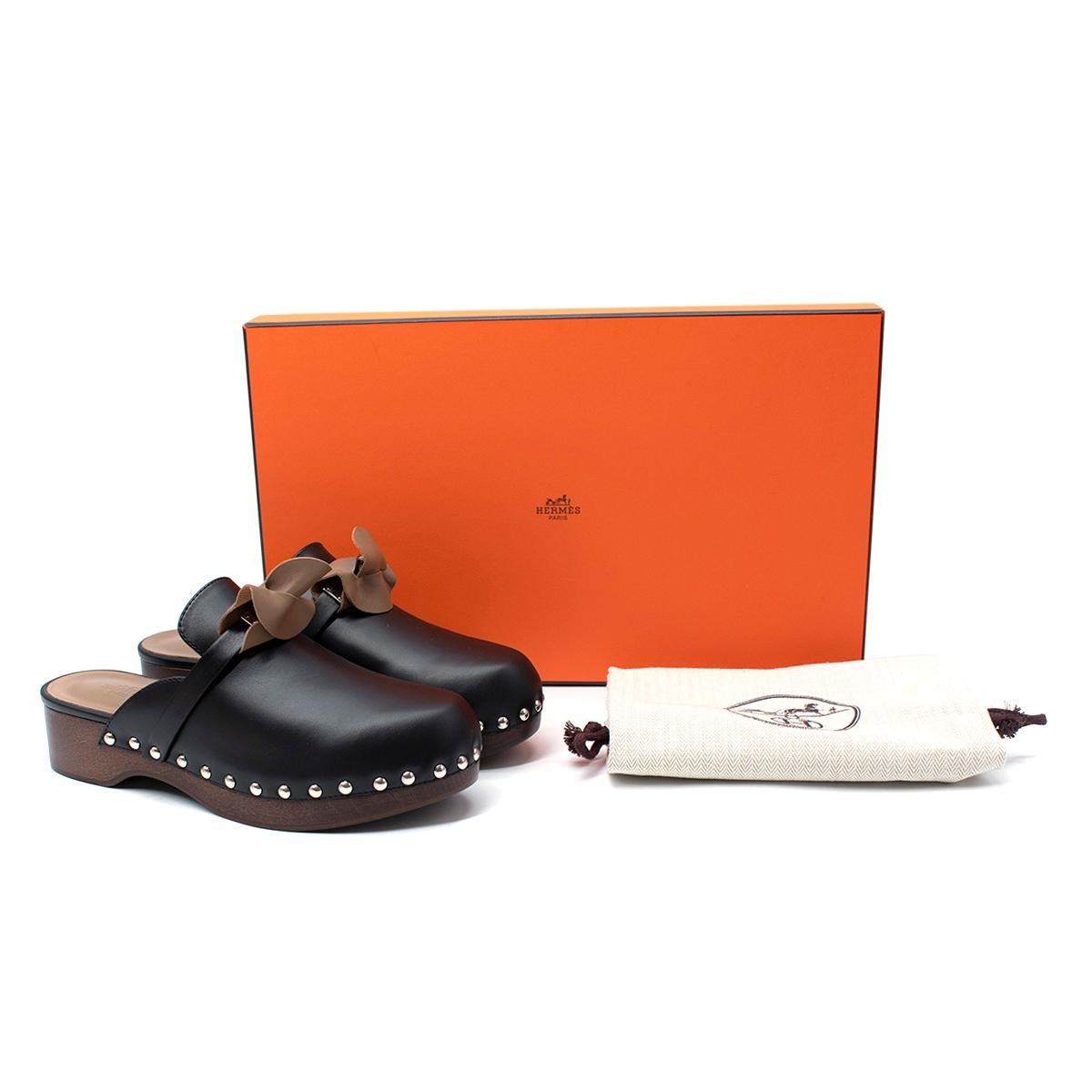Hermes Black Calfskin Carlotta Mule Clogs

- Clog crafted in black calfskin with beechwood platform & sole
- Black leather sole with black rubber insert
- Palladium plated classic kelly buckle
- Palladium plated studs
- Hazelnut goatskin insole and