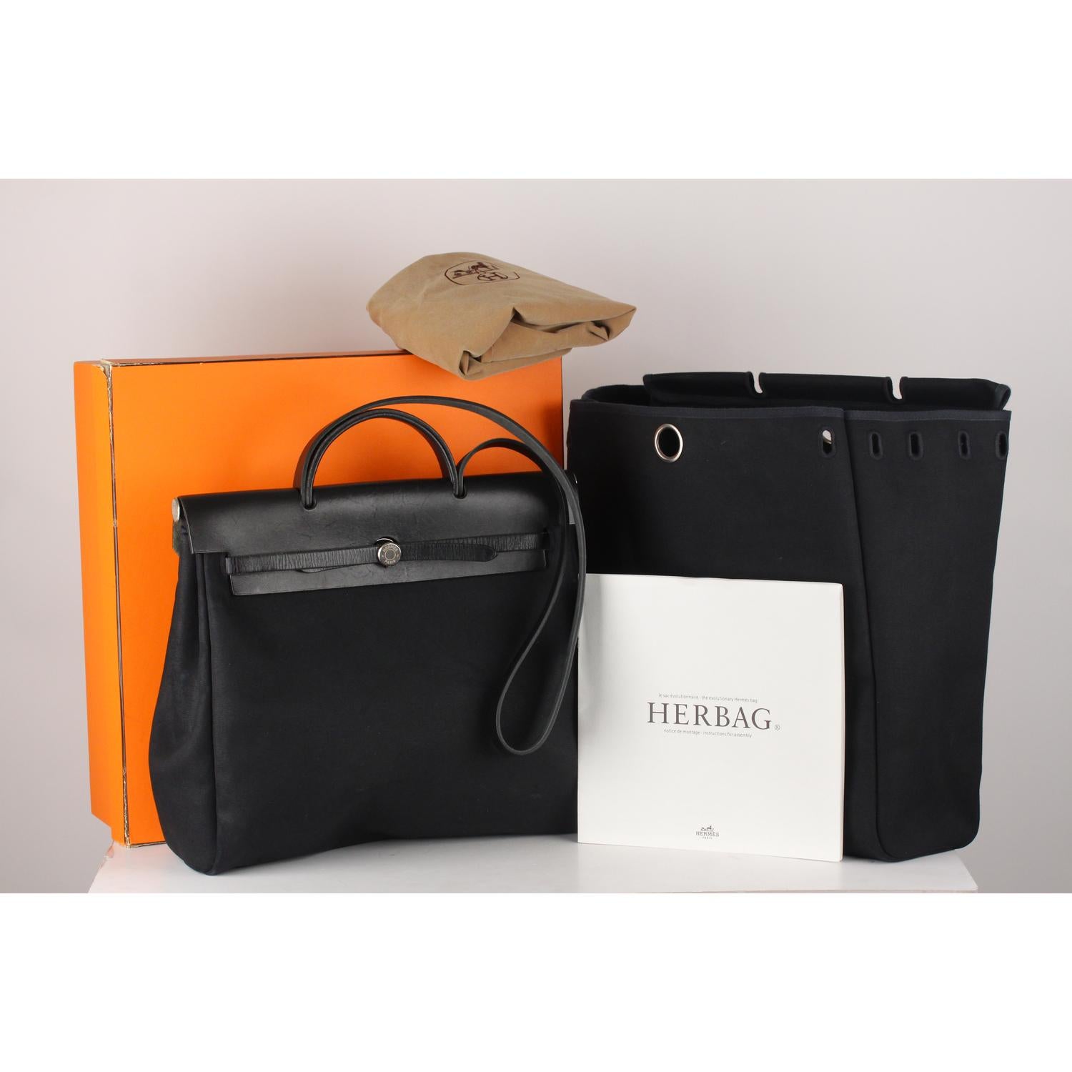 Beautiful Hermes 'Herbag' crafted in black color. Comes with two interchangeable canvas bottoms;  The body is made from canvas but the top is crafted from leather. It comes with long straps for shoulder or across body carry. The bag is locked by