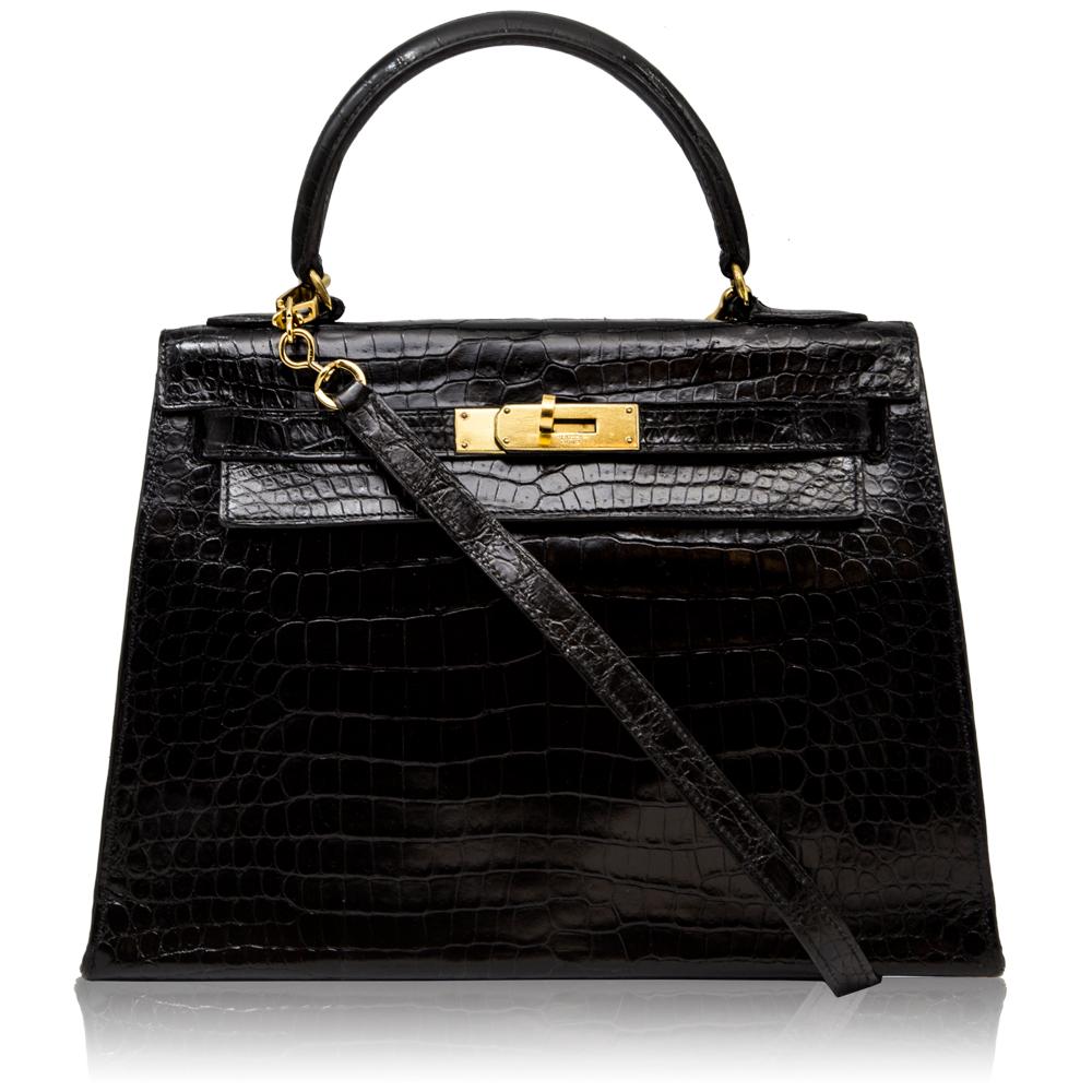 Crafted from black crocodile leather, this vintage 28cm Kelly Sellier bag is offset with gold-tone hardware and features a medium-handle, an adjustable crossbody shoulder strap and a goatskin-lined interior which opens to reveal a wide internal